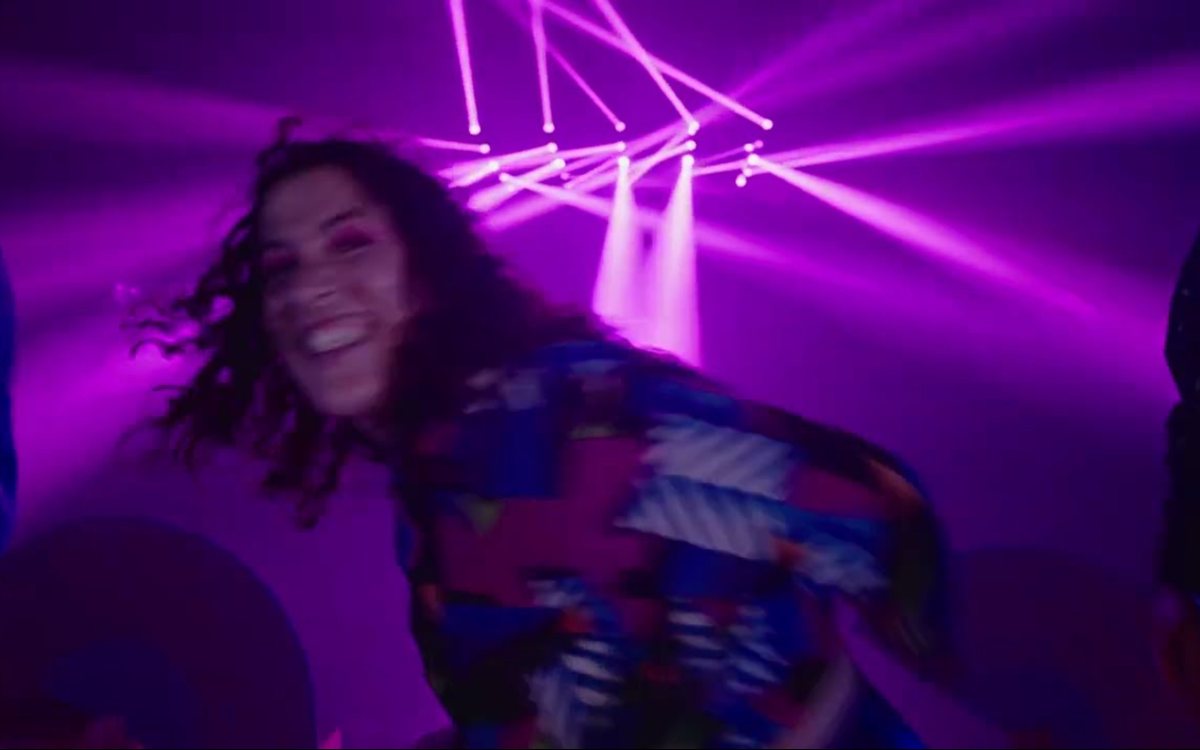 Una bailarina baila bajo focos morados en el spot Salta con Santander SMusic